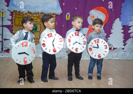 Les enfants . Les participants à la maternelle participent à un événement du nouvel an. Des petits garçons vêtus de costumes festifs de costume. Un enfant joyeux tenant un grand Banque D'Images