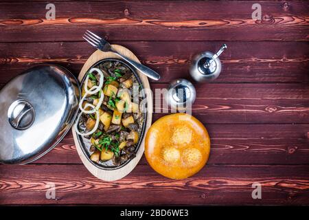 Kuurdak - plat de viande traditionnel fabriqué en Asie centrale. Servir sur une poêle chaude avec une meuleuse au poivre et du pain standard. Vue de dessus Banque D'Images