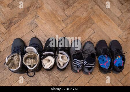 Quatre paires de bottes pour la randonnée sur le sol en bois. Vue de dessus des chaussures pour le tourisme. Espace de copie. Banque D'Images