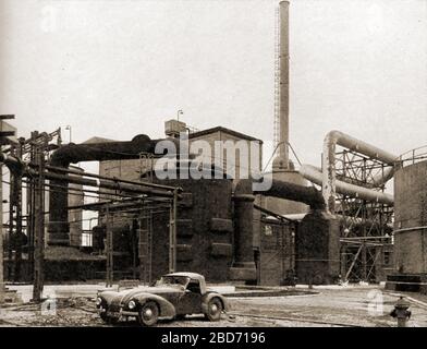 Une photo d'une usine d'acide sulfurique construite par Simon Carves ingénierie avec une voiture de sport moderne ( Frazer Nash BMW des années 1930?) de l'heure. Fondée en 1878 par Henry Simon en association avec François Carvès, la société au début du XXe siècle était la première entreprise britannique à construire des fours à coke et des usines d'acide sulfurique. Banque D'Images