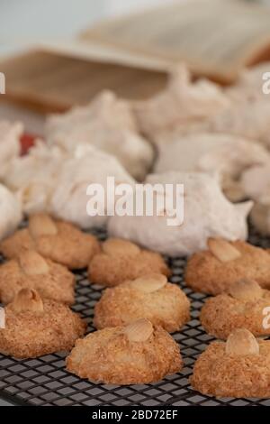 Cuisson de la Pâque (Pesach) - biscuits aux amandes macarons et gâteaux de meringue à la noix de coco, présentés sur un plateau de refroidissement en fil Banque D'Images