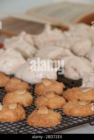 Cuisson de la Pâque (Pesach) - biscuits aux amandes macarons et gâteaux de meringue à la noix de coco, présentés sur un plateau de refroidissement en fil Banque D'Images