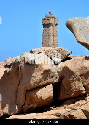 Le phare de Ruz sur la célèbre Côte de granit rose (côte de granit rose en français) derrière de grandes roches à Ploumanac'h en France Banque D'Images