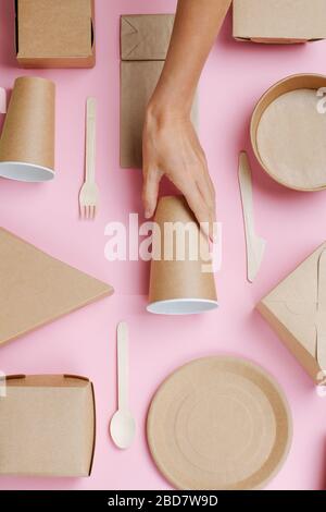 Tasse de placement à la main femelle au milieu de la composition écologique de vaisselle Banque D'Images