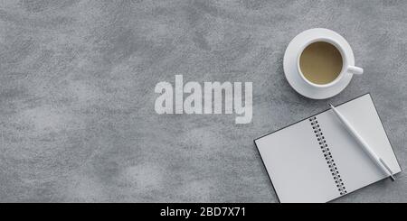 bureau en béton avec ordinateur portable, stylo et tasse à café vue de dessus tourné sur un fond en béton gris illustration tridimensionnelle Banque D'Images