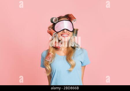 Bonne femme de ménage dans les bigoudis et masque pour dormir Banque D'Images