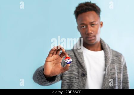 Citoyen africain de l'Amérique tenant des autocollants avec le texte de vote Banque D'Images