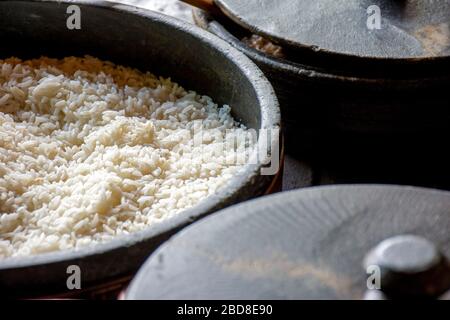 Pots d'argile avec riz blanc préparés sur le poêle à bois et prêts à servir Banque D'Images