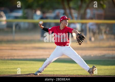 pichet de baseball en uniforme rouge à l'adolescence, à la suite sur la butte Banque D'Images