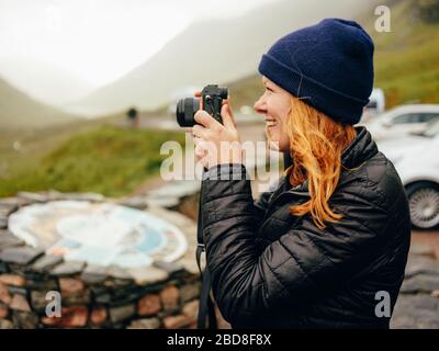 Femme photographiant trois Sœurs de Glencoe, par temps humide Banque D'Images