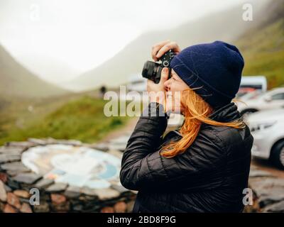 Femme photographiant trois Sœurs de Glencoe, par temps humide Banque D'Images