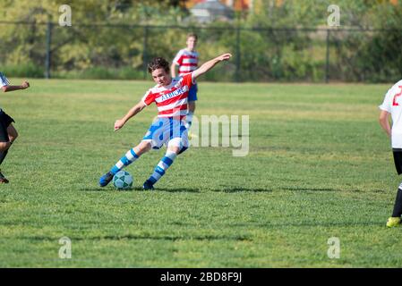 Un joueur de football en adolescence sur le point de frapper le ballon sur un coup de pied libre Banque D'Images