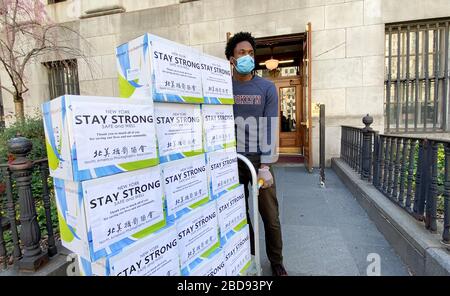 New York, États-Unis. 7 avril 2020. Le 6 avril 2020, un travailleur de Brooklyn Borough Hall reçoit des gants donnés par la North America Photography Association à New York, aux États-Unis. Les communautés chinoises américaines aux États-Unis font des efforts difficiles pour faire don de fournitures médicales aux hôpitaux, aux postes de police et aux résidents locaux afin de réduire la pénurie et de lutter contre la COVID-19 dans le pays. Crédit: Xinhua/Alay Live News Banque D'Images