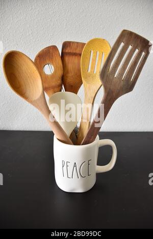 Spatules de cuisine dans une tasse isolé de fond blanc en bois Banque D'Images