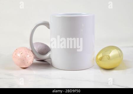 Cette maquette inspirée de Pâques est dotée d'un mug à café de 11 onces entouré d'œufs de Pâques dorés, roses et violettes. Banque D'Images