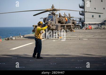 GOLFE ARABIQUE (23 mars 2020) un hélicoptère d'attaque AH-64 Apache du 1e Escadron du 17ème Régiment de cavalerie, Escadron de reconnaissance d'attaque lourde effectue des qualifications d'atterrissage sur le pont de vol de la base maritime expéditionnaire USS Lewis B. Puller (ESB 3). Lewis B. Puller est déployé dans la 5ème zone d'opérations de la flotte des États-Unis à l'appui des opérations de sécurité maritime pour rassurer les alliés et les partenaires et préserver la liberté de navigation et de libre circulation du commerce dans la région. (ÉTATS-UNIS Photo du corps marin par le Cpl Haley Buker) Banque D'Images