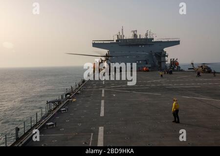 GOLFE ARABIQUE (23 mars 2020) un hélicoptère d'attaque AH-64 Apache du 1e Escadron du 17ème Régiment de cavalerie, Escadron de reconnaissance d'attaque lourde effectue des qualifications d'atterrissage sur le pont de vol de la base maritime expéditionnaire USS Lewis B. Puller (ESB 3). Lewis B. Puller est déployé dans la 5ème zone d'opérations de la flotte des États-Unis à l'appui des opérations de sécurité maritime pour rassurer les alliés et les partenaires et préserver la liberté de navigation et de libre circulation du commerce dans la région. (ÉTATS-UNIS Photo du corps marin par le Cpl Haley Buker) Banque D'Images