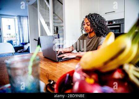 Rotterdam, Pays-Bas. 7 avril 2020. Une femme travaille chez elle. Le gouvernement néerlandais a commandé la fermeture de toutes les écoles et de tous les bureaux jusqu'à nouvel ordre afin de contrôler la propagation du Coronavirus COVID-19. Les étudiants doivent être scolarisés à la maison avec des moyens numériques tels que des ordinateurs portables, des tablettes numériques ou des téléphones mobiles. Crédit: SOPA Images Limited/Alay Live News Banque D'Images