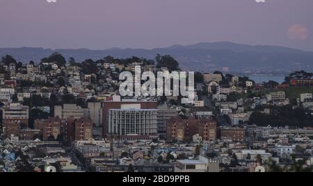 San Francisco, États-Unis. 7 avril 2020. L'hôpital général de San Francisco Zuckerberg est considéré comme une super lune rose s'élève à travers la brume à droite à San Francisco le mardi 7 avril 2020. La pleine lune d'avril est la plus proche de la terre en 2020. Photo de Terry Schmitt/UPI crédit: UPI/Alay Live News Banque D'Images