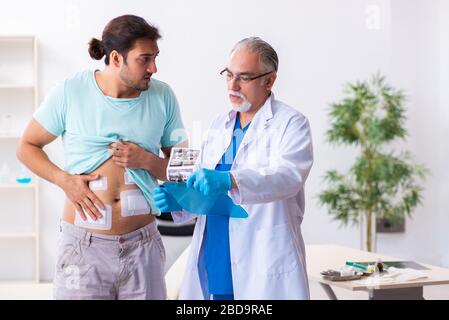 Homme blessé en visite chez un médecin de sexe masculin expérimenté Banque D'Images