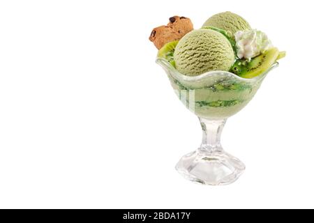 Service de glace crémeuse au kiwifruit faite à la main dans un plat en verre aux fruits frais, une poupée de crème fouettée et un cookie isolé sur blanc avec spac copie Banque D'Images