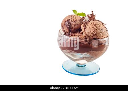 Vue latérale d'une portion de crème glacée au chocolat garnie de menthe et de flocons de chocolat dans un bol en verre isolé sur blanc avec copyspace