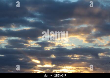 Les rayons du soleil traversent les nuages sombres. Magnifique ciel spectaculaire au coucher du soleil ou au lever du soleil. Banque D'Images