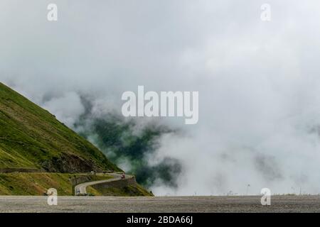 La route qui traverse les montagnes de Fagaras vues d'en haut parmi le brouillard, Transfagarasan, Roumanie Banque D'Images