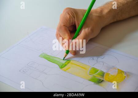 La main de l’homme dessine une bouteille avec des crayons de couleur. Banque D'Images