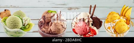 Vue sur un assortiment de desserts tropicaux colorés à base de crème glacée sundae sur une table en bois. Banque D'Images