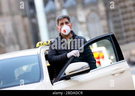 Cologne, Allemagne. 7 avril 2020. Un chauffeur de taxi se protège lui-même et ses clients avec des gants et un respirateur. Koln, le 7 avril 2020 | utilisation dans le monde crédit: dpa/Alay Live News Banque D'Images