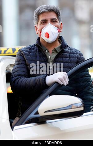 Cologne, Allemagne. 7 avril 2020. Un chauffeur de taxi se protège lui-même et ses clients avec des gants et un respirateur. Koln, le 7 avril 2020 | utilisation dans le monde crédit: dpa/Alay Live News Banque D'Images