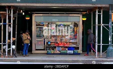 Un kiosque de journaux est accroché sous un échafaudage de trottoir à une entrée du métro sur W 14 St, Manhattan, New York, NY. Banque D'Images