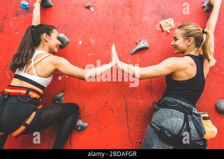 Les athlètes grimpent sur une roche raide, grimpant sur un mur artificiel à l'intérieur. Sport extrême et concept de bouldering Banque D'Images