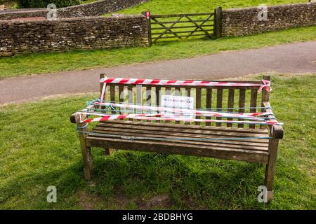 Garez le banc avec panneau de ne pas s'asseoir et ruban d'avertissement blanc et rouge, Tetbury, Gloucestershire, Royaume-Uni