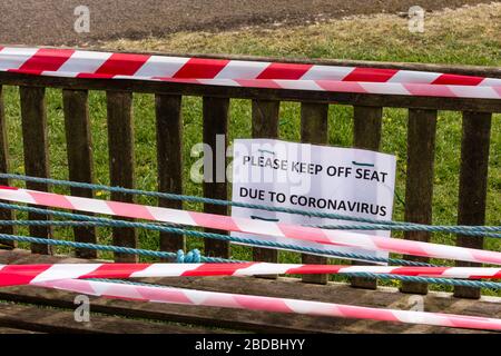 Garez le banc avec panneau de ne pas s'asseoir et ruban d'avertissement blanc et rouge, Tetbury, Gloucestershire, Royaume-Uni Banque D'Images