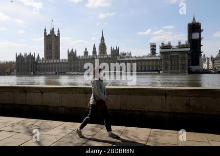 Londres, Londres, Royaume-Uni. 7 avril 2020. Une personne portant un masque de visage marche le long de la Tamise, le 7 avril 2020, devant le Palais de Westminster, à Londres, en Grande-Bretagne. Crédit: Tim Irlande/Xinhua/Alay Live News Banque D'Images