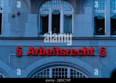 Lettrage éclairé sur un mur de maison, traduit en anglais: Droit du travail, droit du travail néon panneau, Arbeitsrecht Banque D'Images