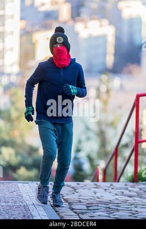 garçon courir à l'étage avec masque chirurgical fait maison Banque D'Images