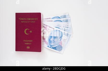 Passeport turc et lot de 100 billets de Lira (TRY) turcs isolés sur fond blanc. Concept d'argent et de voyage. Banque D'Images