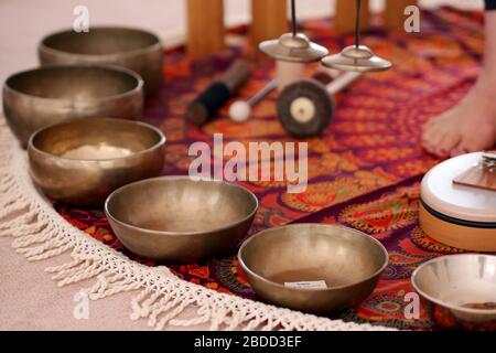 Les bols de chant tibétain se rapprochant pour une séance de thérapie de guérison sonore avec d'autres instruments en arrière-plan. Banque D'Images