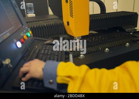 Découpe au laser et opérateur sur le panneau de commande, technologie industrielle moderne CNC Banque D'Images