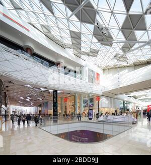 Rues commerçantes à plusieurs niveaux sous le toit plein-ciel. Westfield White City, Londres, Royaume-Uni. Architecte : UNStudio, 2018. Banque D'Images