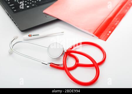 Thermomètre médical stéthoscope rouge sur table blanche. Médecins équipement professionnel sur l'espace de travail. Concept médical de santé. Rendez-vous avec un médecin Banque D'Images