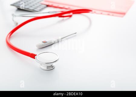 Thermomètre médical stéthoscope rouge sur table blanche. Médecins équipement professionnel sur l'espace de travail. Concept médical de santé. Rendez-vous avec un médecin Banque D'Images