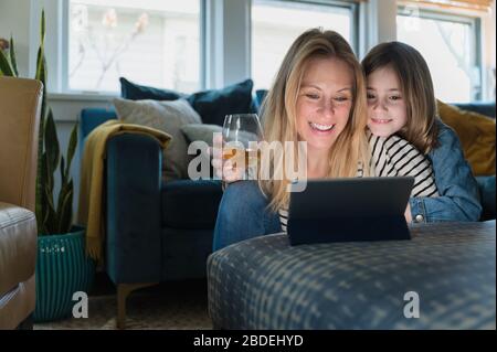 Mère et fille (6-7) regardant l'ordinateur portable à la maison Banque D'Images
