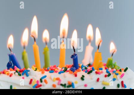 Bougies d'anniversaire allumées sur le gâteau Banque D'Images