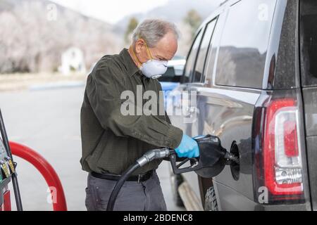 Homme portant des gants chirurgicaux et un masque ravitailleur en carburant station Banque D'Images