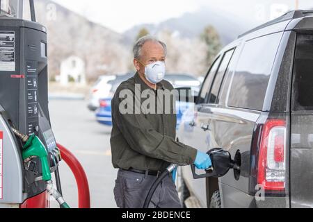 Homme portant des gants chirurgicaux et un masque ravitailleur en carburant station Banque D'Images