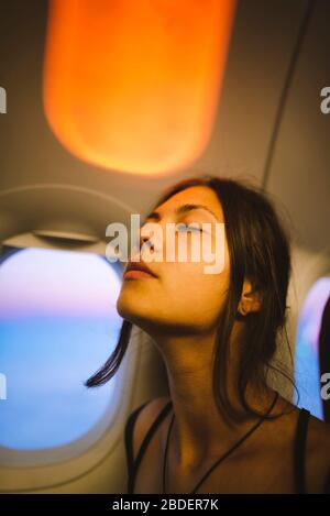 Portrait de la jeune femme en avion illuminé par la lumière du coucher du soleil Banque D'Images